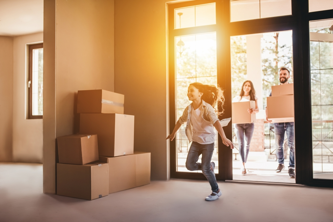 A family of three moving boxes into their new home